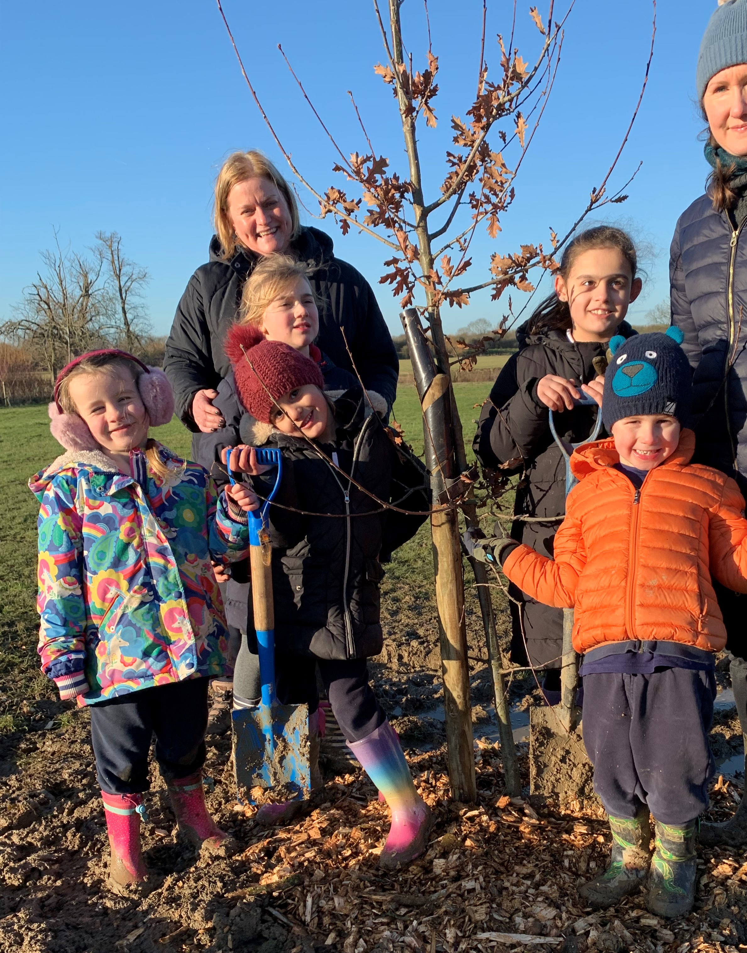 Sarah Bishop with pupils planting a tree